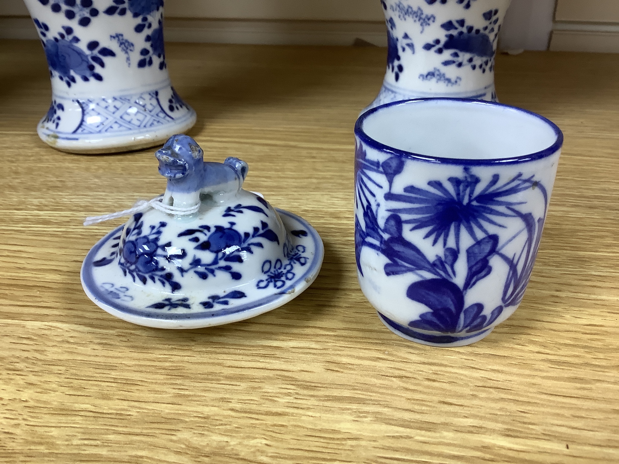 A pair of lidded Chinese blue and white vases, c.1900, Kangxi marks, 23cm high, together with two small Japanese vases, and a cup and saucer (6)